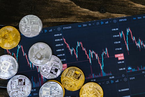 Free Close-up of gold and silver cryptocurrency coins on a digital trading chart. Stock Photo